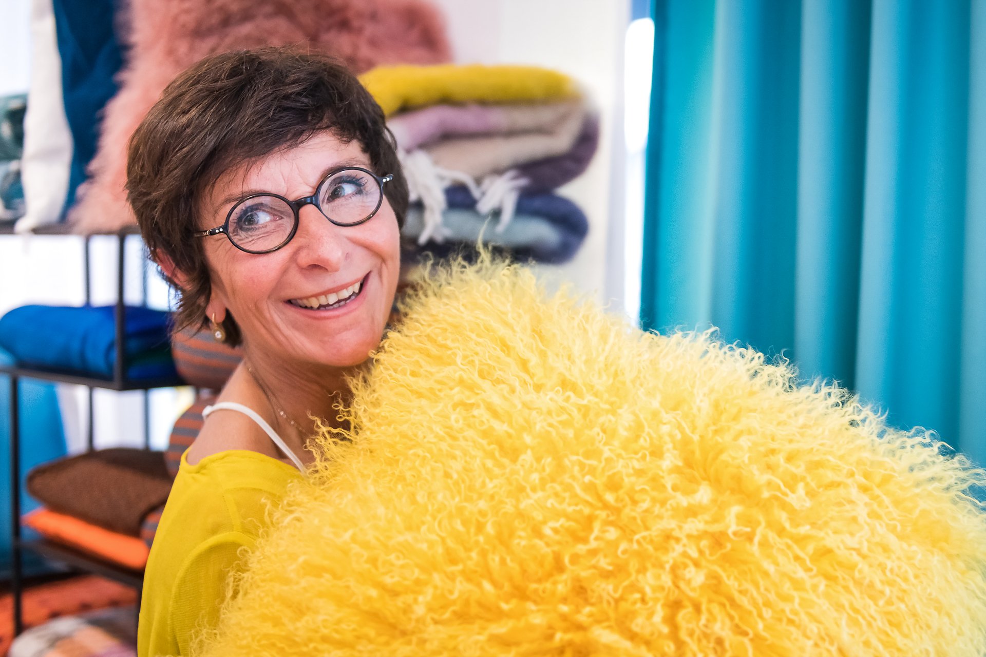 Portrait d'entrepreneur : Isabelle Dubois, architecte d'intérieur au hublot de sa roulotte en construction. Portrait en lumière naturelle réalisé au magasin de décoration X38 par AUrore Delsoir photographe d'entreprise