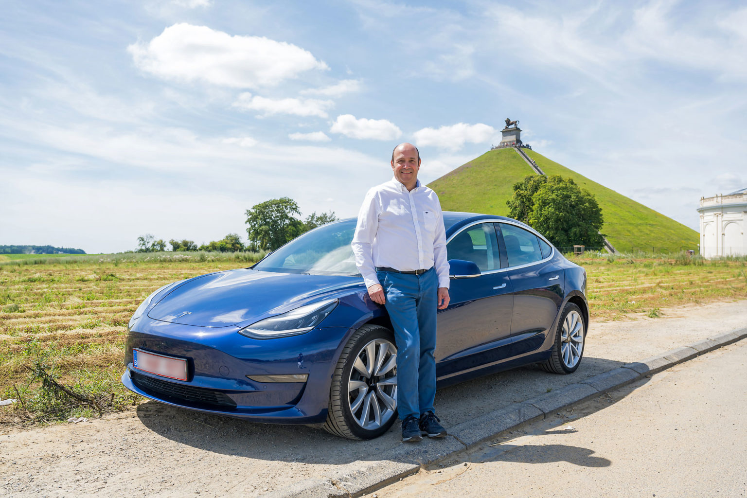 Frederic Witmeur qui pose avec sa Tesla au Lion de Waterloo