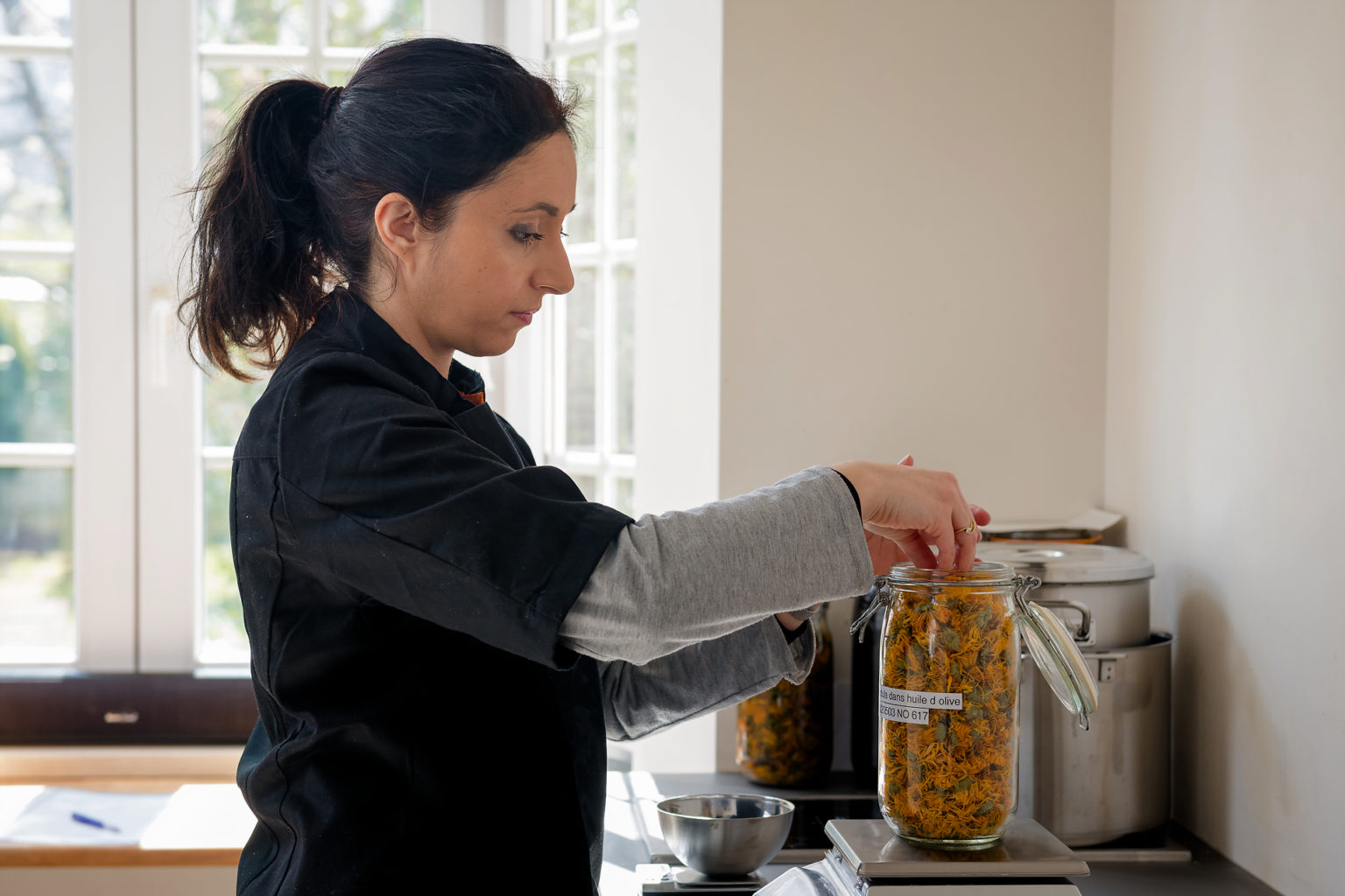 Aline Assadourian en pleine préparation d'un macérat de calendula, Alinessence par Aurore Delsoir Photobiographe