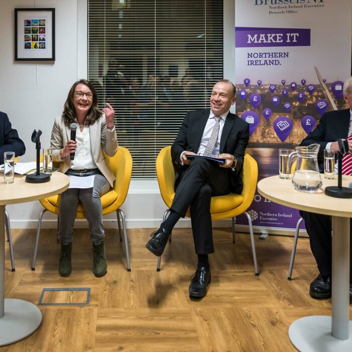 Quatre personnes sont assis autour d'une table ronde équipée de microphones lors de l'événement "Make it Northern Ireland"