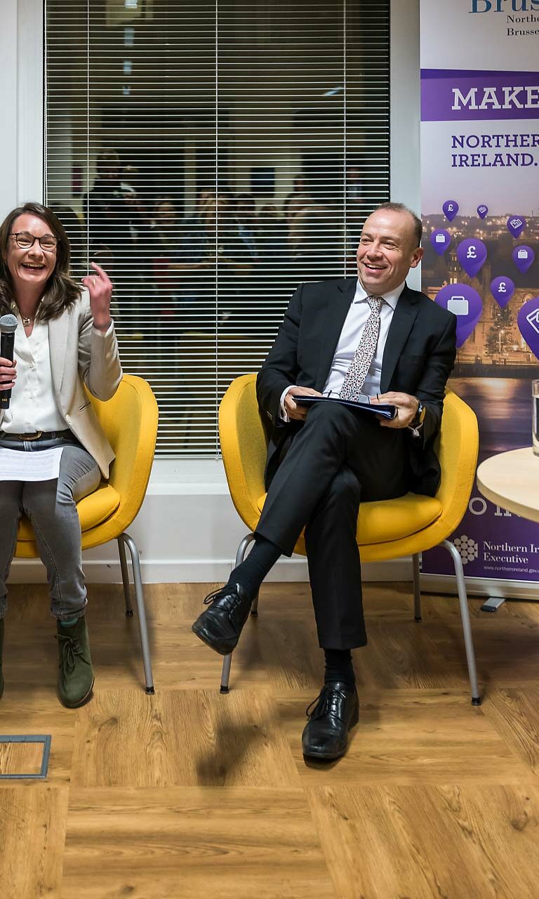 Quatre personnes sont assis autour d'une table ronde équipée de microphones lors de l'événement "Make it Northern Ireland"