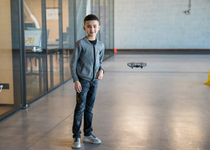 Un petit garçon souriant qui pose dans le couloir d'une école